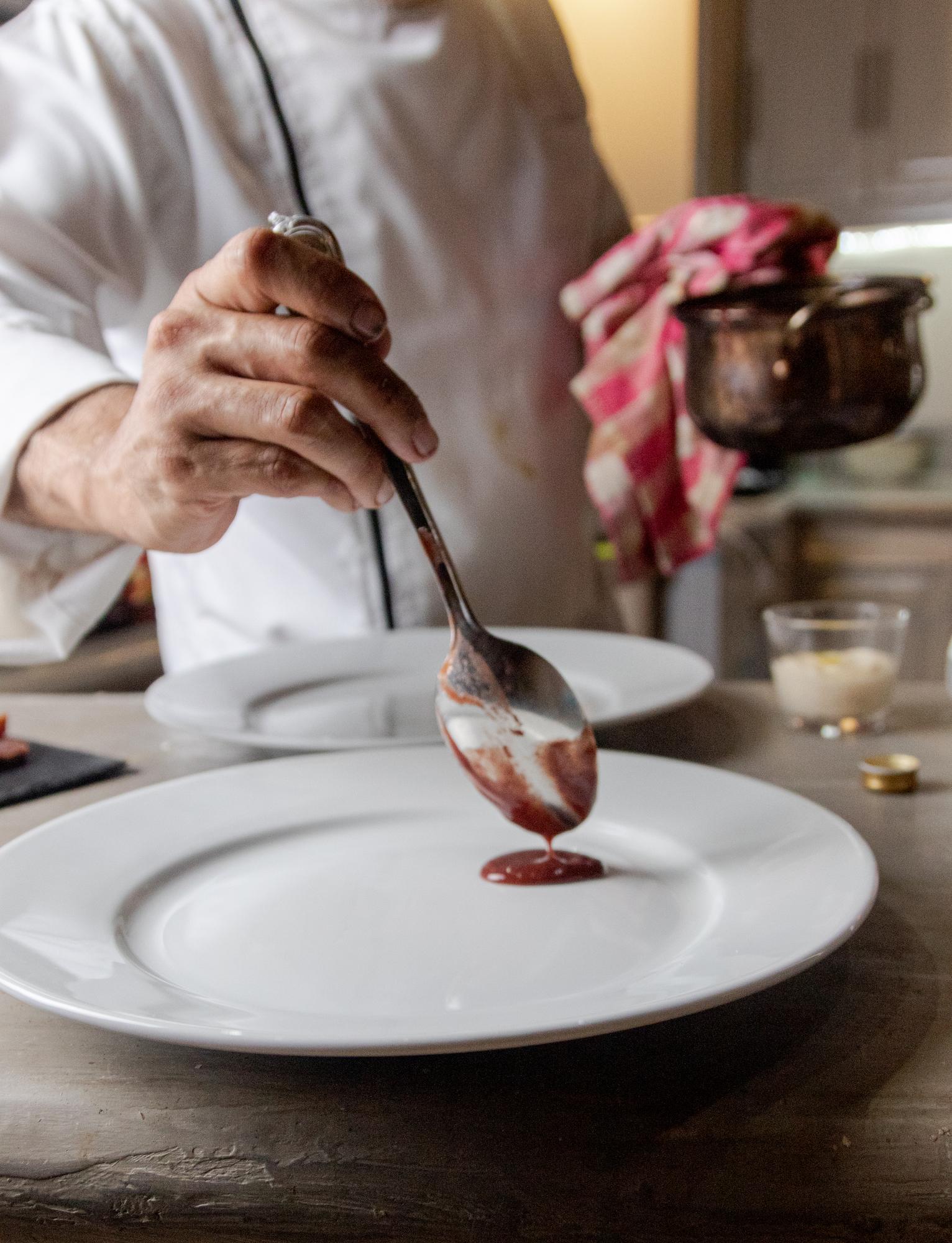Chef pochylny nad talerzem z dekoracją
